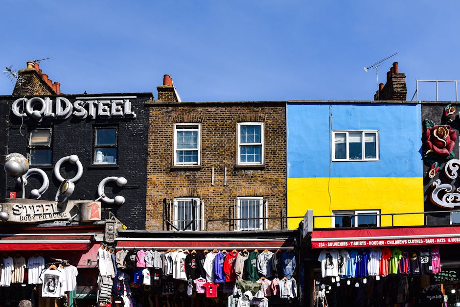 The photograph depicts a multi-story brick building labeled 'Camden Lock' with large arched windows on the upper floor and smaller rectangular windows on the lower floors. A prominent blue sign with w
